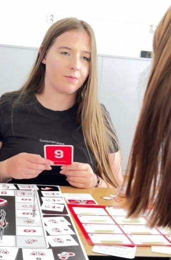 Studentka drží kartu STRATE9Y během hry